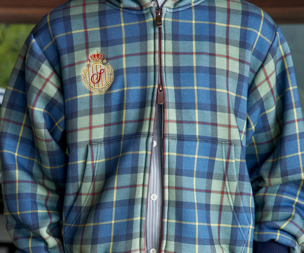 Source photo three: garment-only crop resolving the two zip sliders and their brown leather pull-tabs